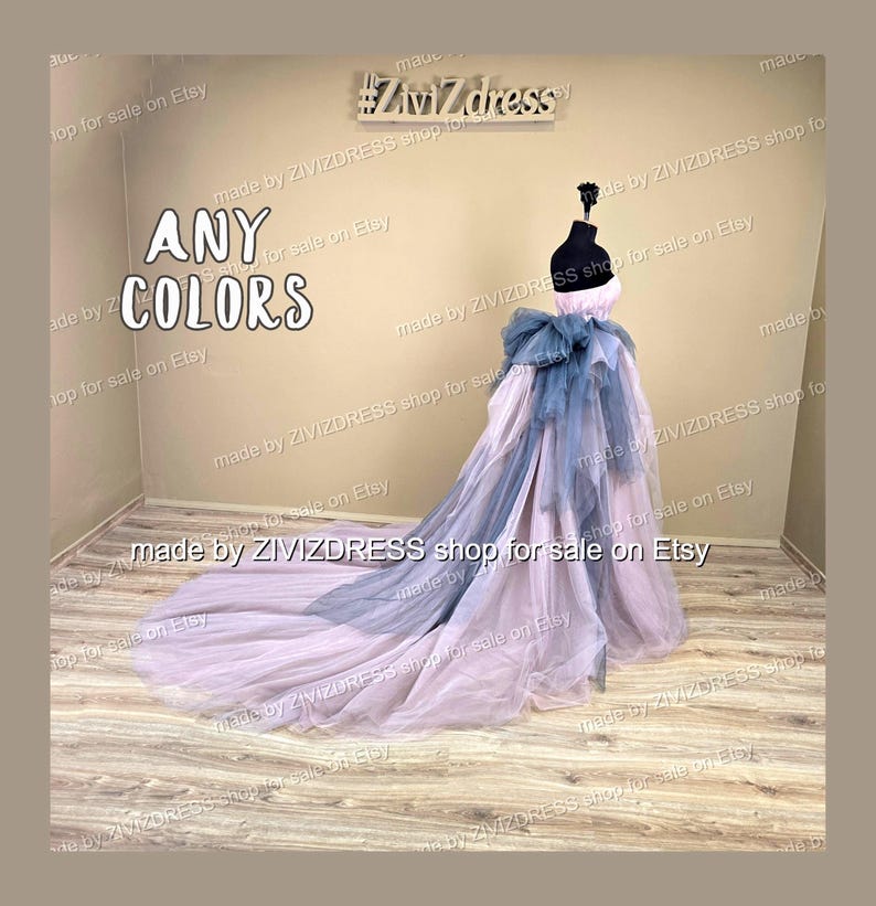 May include: A strapless, floor-length gown in soft pink and blue-grey tulle, displayed on a mannequin. The dress features a layered skirt and a large bow detail at the waist. The text "ANY COLORS" is visible.