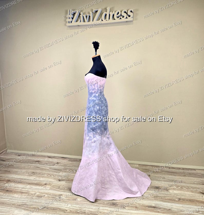 May include: A strapless, floor-length gown on a mannequin. The dress features a gradient design, transitioning from a light pink at the bottom to a blue and white pattern in the middle, and back to pink at the top. The text "#ZiviZdress" is visible.