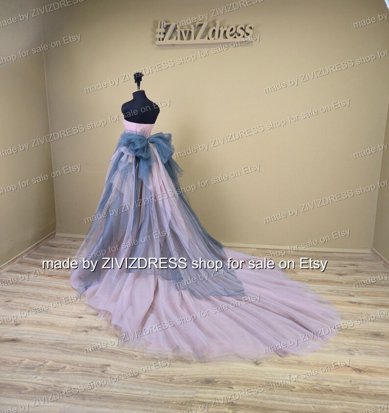 May include: A formal gown displayed on a mannequin. The dress has a pink bodice, a blue bow, and a layered skirt that fades from blue to pink. The train trails across the floor. The text "made by ZIVIZDRESS shop for sale on Etsy" is visible.