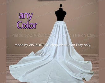 Puede incluir: Una falda blanca larga hasta el suelo con una cola larga y una fila vertical de pequeños botones en la parte central trasera, exhibida en un maniquí negro. El texto "any Color" y "made by ZIVIZDRESS shop for sale on Etsy only" aparece en la imagen.