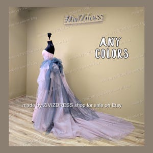 May include: A strapless formal gown in pink, blue, and gray, displayed on a mannequin. The dress features a long, flowing train and a layered design. The text "ANY COLORS" is visible.