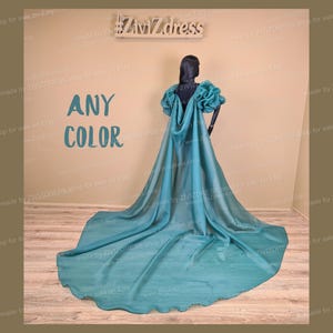 Puede incluir: Un vestido de noche azul turquesa con una cola larga y un corpiño con volantes. El vestido se muestra en un maniquí. El texto "ANY COLOR" es visible en la imagen.
