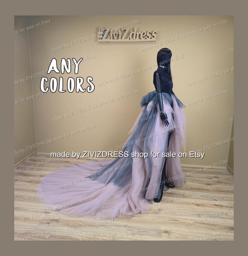 May include: A black mannequin wearing a layered tulle skirt with a long train. The skirt features layers of pink, grey, and black tulle. The text "ANY COLORS" is displayed in white.