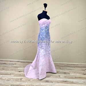 May include: A strapless, floor-length gown on a black mannequin. The dress features a gradient design, transitioning from a light pink bodice to a blue and white patterned midsection, and back to pink at the flared hem. The text "made by ZIVIZDRESS shop for sale on Etsy" is visible.