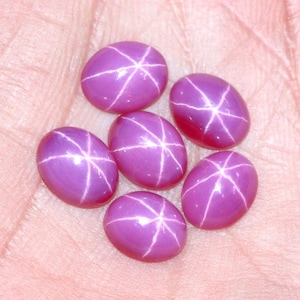 Può includere: Sei pietre preziose di rubino stella rosa con un motivo a forma di stella al centro di ogni pietra.