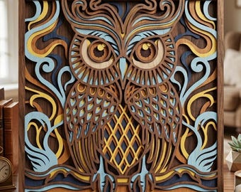 Puede incluir: Una obra de arte de búho de madera en capas. El búho está intrincadamente cortado de madera, con tonos de marrón, azul, amarillo y beige. La obra de arte se exhibe en un soporte de madera, mostrando el diseño detallado y la construcción en capas.