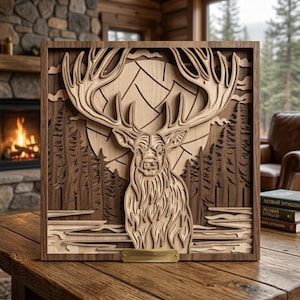 May include: A wooden, layered art piece featuring a detailed elk design. The elk is centered, with large antlers and intricate fur detailing. The background includes a mountain range, trees, and a full moon. The piece is framed in a dark wood.