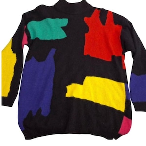 May include: Black sweater with a mock turtleneck and long sleeves. The sweater features large, colorful abstract shapes in red, yellow, green, blue, and pink. The sweater is a vintage style.