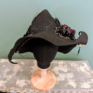 Chapéu de bruxa desleixado preto e vermelho rubi, feito sob medida e adornado à mão.