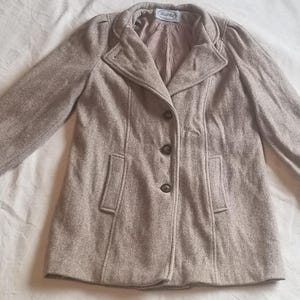 May include: A beige wool coat with a button closure and two pockets. The coat has a herringbone pattern and a slightly puffed sleeve.