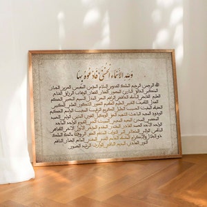 May include: A framed print with a white background and gold Arabic calligraphy. The text reads "وينه الانماء السنى فادعوه بها" which translates to "Where is the growth of the year, so call upon it".
