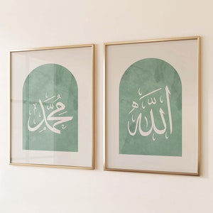 Puede incluir: Dos impresiones enmarcadas con marcos dorados. Las impresiones presentan caligrafía árabe en blanco sobre un fondo verde. La caligrafía de la impresión de la izquierda dice "Muhammad" y la caligrafía de la impresión de la derecha dice "Allah".
