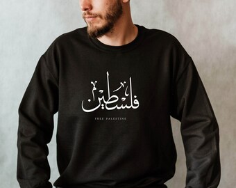 May include: A black sweatshirt with white Arabic text that reads "Free Palestine" in English.