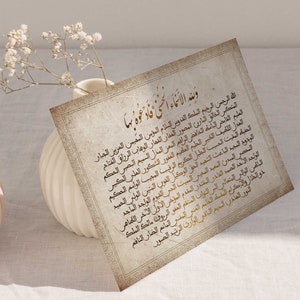 May include: A vintage-style card with an Islamic prayer written in Arabic script in gold lettering on a cream background. The text reads "Wane al-An'ama al-lati fad'a'tu biha".