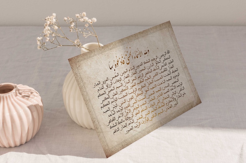 May include: A vintage-style card with an Islamic prayer written in Arabic script in gold lettering on a cream background. The text reads "Wane al-An'ama al-lati fad'a'tu biha".