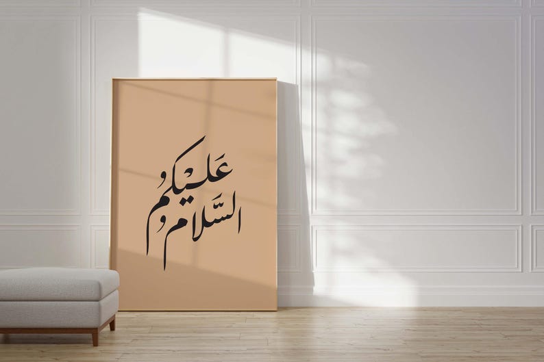 May include: A beige framed poster with black Arabic calligraphy that reads "عليكَ و علينا" which translates to "On you and on us".