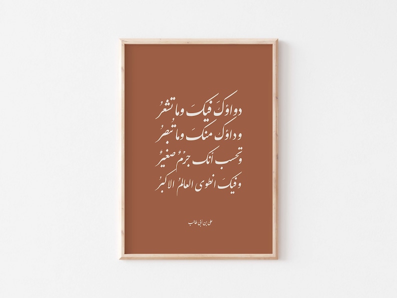 May include: A framed print with a brown background and white Arabic calligraphy. The text reads "Dawa'uk fika wa ma tash'ur, wa da'uk ming wa ma tubsir, wa tahsib annaka jazm saghir, wa fika intawi al-'alam al-akbar." The print is signed "Ali ibn Abi Talib".