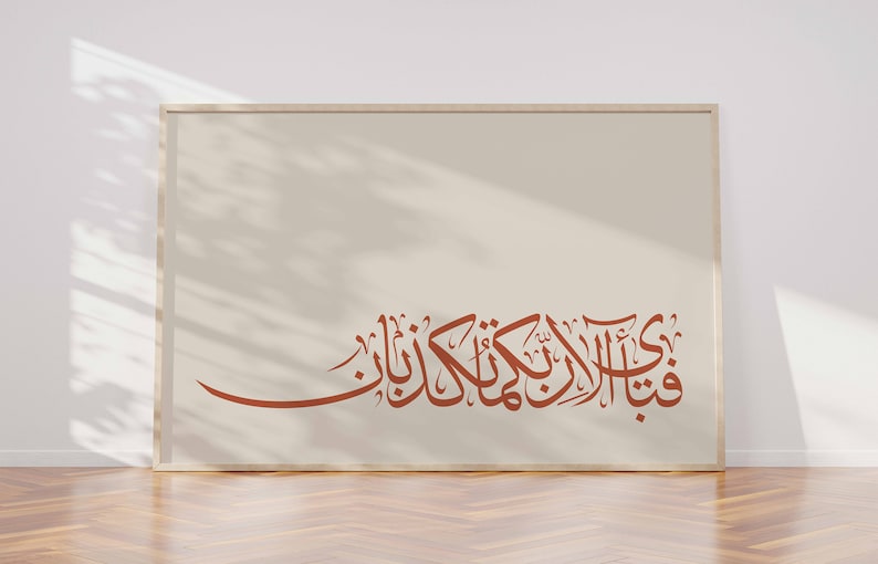 May include: A framed print with a beige background and a brown Arabic calligraphy inscription. The inscription reads "قُلْ هُوَ اللَّهُ أَحَدٌ".