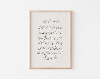 May include: A framed print with a white background and black Arabic calligraphy. The text reads "Bismillah ar-Rahman ar-Rahim" and continues with a passage from the Quran.