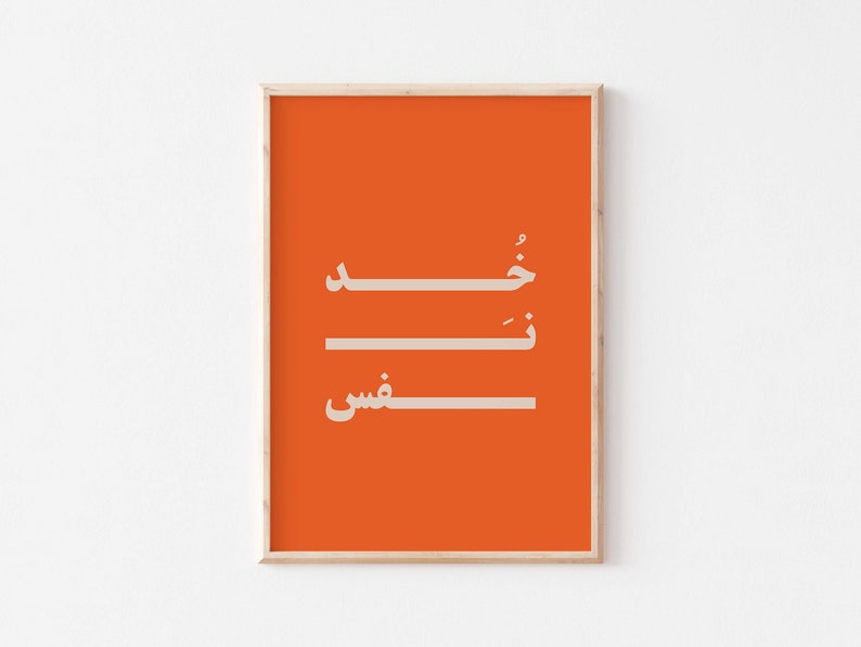 Puede incluir: Una impresi&oacute;n enmarcada con fondo naranja y texto &aacute;rabe blanco que dice "Shukran" que significa "Gracias" en &aacute;rabe.