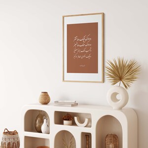 May include: A white, modern console table with arched shelves. The table is decorated with a framed print of Arabic calligraphy, a vase with dried pampas grass, a ceramic vase, a woven basket, and a gold vase.