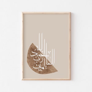 May include: A framed print with a beige background and a brown watercolour-style shape in the centre. The shape contains white Arabic calligraphy that reads "Allah is the light of the heavens and the earth".