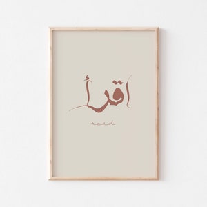 Puede incluir: Una impresi&oacute;n enmarcada con un fondo beige que presenta la palabra &aacute;rabe "اقرأ" en caligraf&iacute;a marr&oacute;n, que se traduce como "leer" en espa&ntilde;ol.