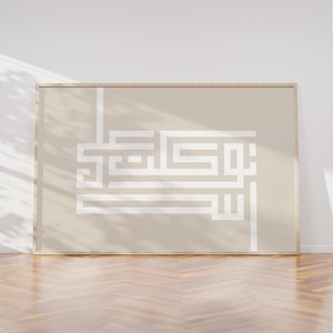 May include: A framed print with a beige background and a white geometric design. The design is a stylized Arabic calligraphy.