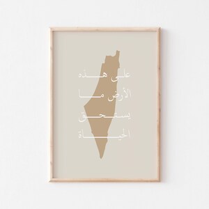 May include: A beige print with a brown outline of the country of Palestine. The print features the Arabic words "Ali Hayda", "Al-Quds", "Biseet", and "Al-Jiblah" in white.