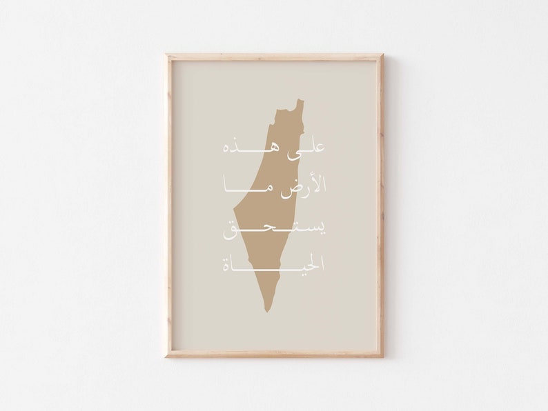 May include: A beige print with a brown outline of the country of Palestine. The print features the Arabic words "Ali Hayda", "Al-Quds", "Biseet", and "Al-Jiblah" in white.