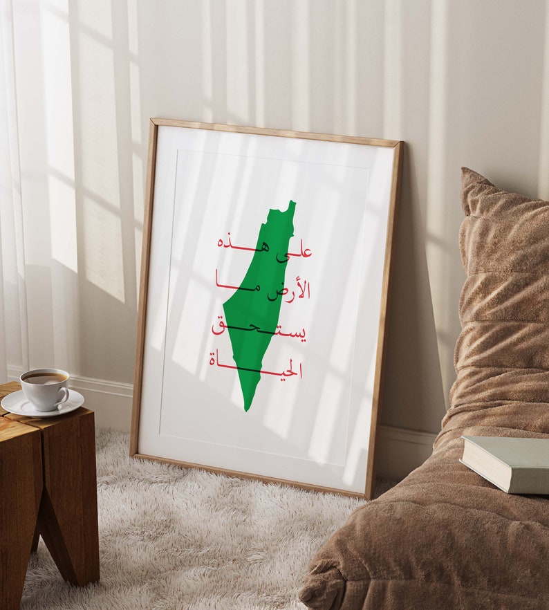 May include: A framed print with a green outline of the country of Palestine. The Arabic words "Palestine", "Free", "My", "Land", "On", "You", and "Palestine" are written in red inside the outline.