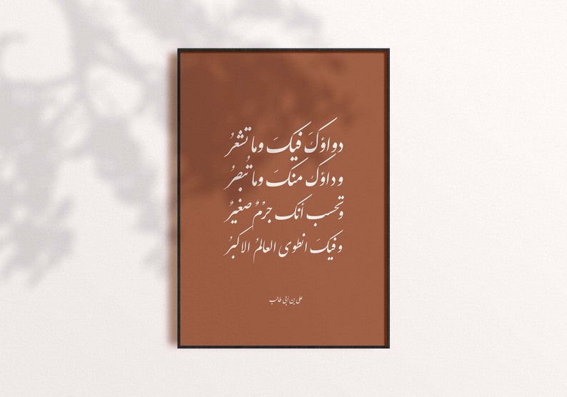 May include: A brown framed print with white Arabic calligraphy. The text reads: "Two oceans meet and we do not see, Two oceans meet and we do not perceive, You think you are a small drop, But within you lies the greatest ocean." The print is signed "Ali ibn Abi Talib".