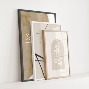 Op de afbeelding: Drie ingelijste prints met abstracte ontwerpen en Arabische kalligrafie in zwart en wit op een beige achtergrond. De lijsten zijn zwart, wit en van natuurlijk hout.