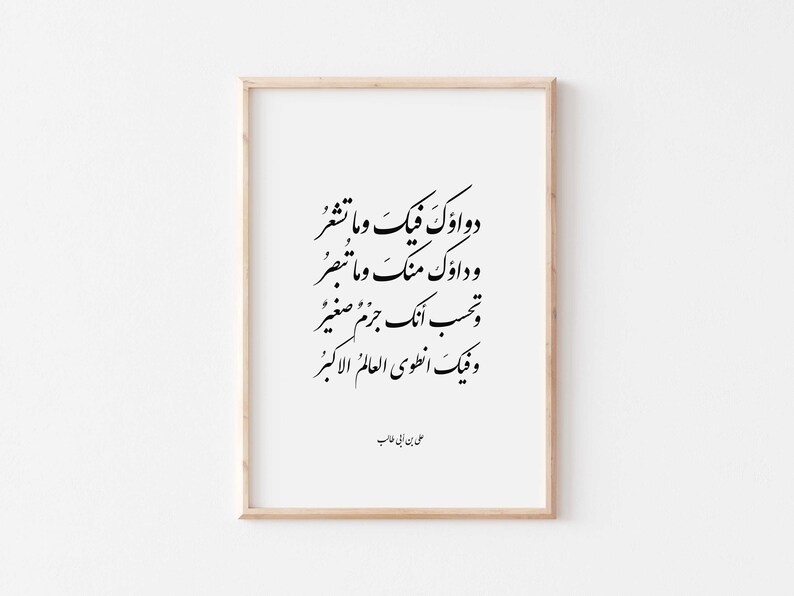 May include: A framed print with black calligraphy in Arabic script. The text reads "Dawa'uk wa ma fiik wa ma tash'ur, wa dawwal min wa ma munawwam, wa ma tubsir, wa tahsib annaka jam'an saghir, jam'an saghir, wa fiik anṭawa al-'alam al-akbar." The print is signed "Ali ibn Abi Talib".