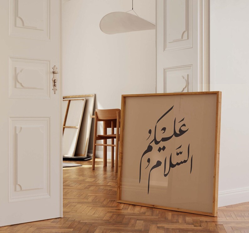 May include: A framed print with Arabic calligraphy in black ink on a beige background. The frame is made of natural wood and has a light brown finish.