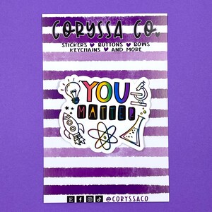 May include: A white sticker with the text "You Matter" in rainbow colors. The sticker is surrounded by small illustrations of a lightbulb, rocket, atom, microscope, and beaker.