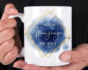 May include: White ceramic mug with a blue watercolor design and gold lettering that reads "Bester Trauzeuge der Welt".