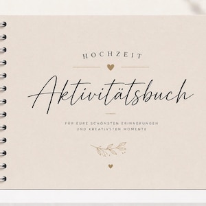 Puede incluir: Un libro de actividades con espiral y cubierta beige. La portada presenta la palabra "HOCHZEIT" sobre la palabra en cursiva "Aktivit&auml;tsbuch". Debajo, se lee "F&Uuml;R EURE SCH&Ouml;NSTEN ERINNERUNGEN UND KREATIVSTEN MOMENTE". Corazones dorados y detalles florales adornan la portada.
