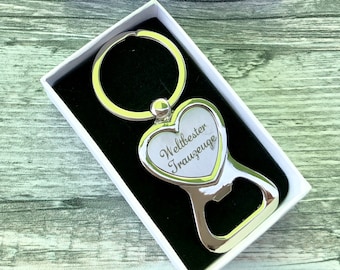 May include: Silver heart-shaped bottle opener with a keychain ring. The heart has an engraved message that reads "Weltbester Trauzeuge".