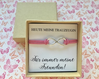 May include: A pink suede bracelet with an infinity symbol charm in a small gift box. The box has a white card inside with the text "Heute meine Trauzeugin" and "Für immer meine Freundin!"