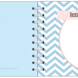 Puede incluir: Cuaderno abierto con espiral y p&aacute;ginas azul claro. La p&aacute;gina izquierda tiene un c&iacute;rculo blanco con un icono de c&aacute;mara y el texto "PLACE FOR A FOTO". La p&aacute;gina derecha tiene un c&iacute;rculo rosa con un icono de cuchara y el texto "Unser Lieblingsrezept f&uuml;r euch:" en una pancarta rosa.