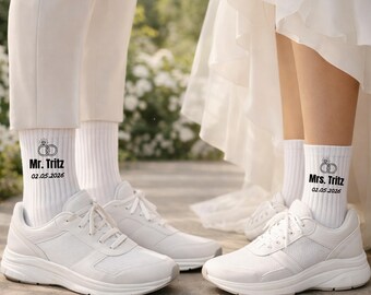May include: White athletic shoes and socks with wedding-themed text. The socks read "Mr. Tritz" and "Mrs. Tritz" with the wedding date 02.05.2026. The shoes are white with white laces.