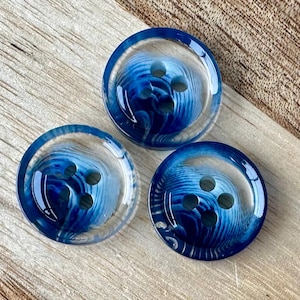 May include: Three blue and white swirl patterned buttons with four holes each.