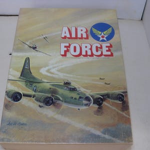 May include: A vintage board game box featuring a green and brown bomber plane flying over a desert landscape. The box is titled "AIR FORCE" with a blue and red Air Force insignia. The game is by the Avalon Hill Game Company.