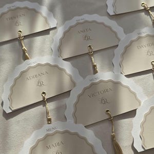 Luxe neutraal trouwmenu met naamplaatje en kwastje | Gepersonaliseerd waaiermenu met schulprand | Elegante plaatskaart met gastnaam
