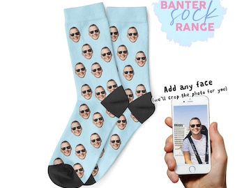 Könnte beinhalten: Hellblaue Socken mit einem sich wiederholenden Muster eines lächelnden Gesichts mit Sonnenbrille. Die Socken haben schwarze Fersen und Zehen. Der Text "Banter Sock Range" befindet sich in einer hellblauen Blase. Der Text "Add any face" steht darunter.