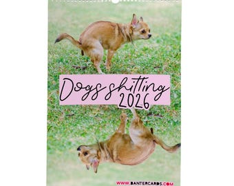 May include: A spiral-bound calendar featuring two images of a small brown dog on green grass. The text "Dogs shitting 2026" is on a pink banner. The website address www.bantercards.com is at the bottom.
