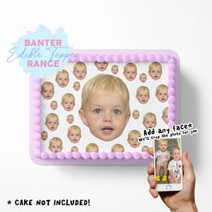 Puede incluir: Una tarta rectangular con un borde lila claro y una parte superior blanca, decorada con múltiples imágenes de la cara de un niño. La tarta está etiquetada como "BANTER Edible Topper RANGE". Un teléfono muestra una foto del niño. El texto en el teléfono dice "Add any face* We'll crop the photo for you".