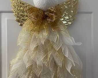 May include: A white angel Christmas decoration with gold wings and a gold bow. The angel is made of mesh and has a white lace ball head.