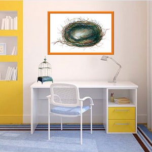 Puede incluir: Un escritorio blanco con un caj&oacute;n amarillo y una jaula para p&aacute;jaros en la parte superior. Un dibujo enmarcado de un nido de p&aacute;jaro cuelga en la pared sobre el escritorio.